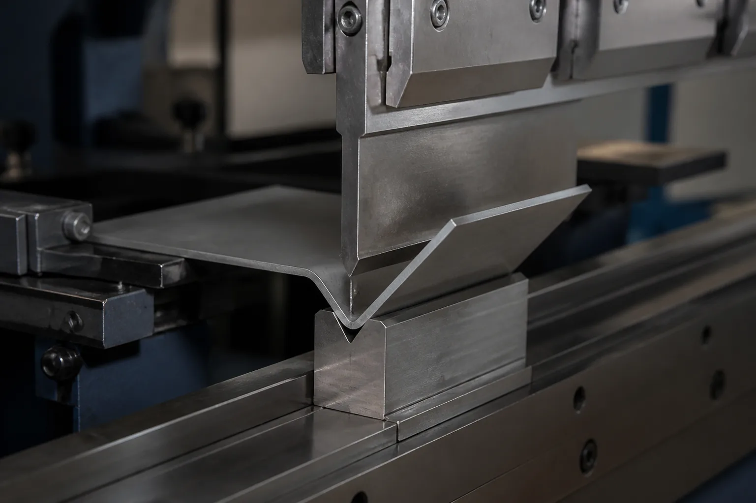 Press brake forming a V bend in a sheet metal blank