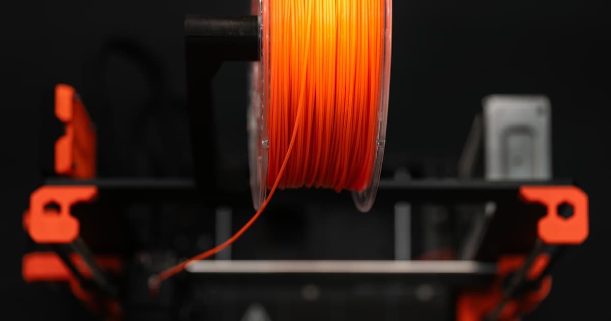 FDM 3D printer extruding thermoplastic filament through a heated nozzle — extrusion-based additive manufacturing in action