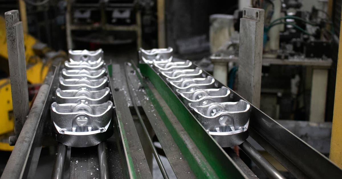 Array of precision CNC machined components in various materials laid out on a workshop table for inspection